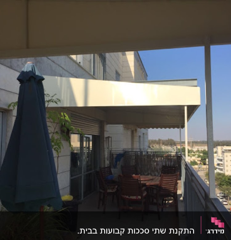 מרפסת עם סוכך לבן מעל שולחן וכיסאות